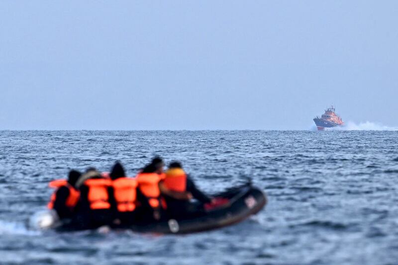A Royal National Lifeboat Institution vessel makes its way towards migrants travelling in an inflatable boat across the English Channel. AFP