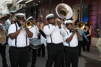 New Orleans, USA - Nov 3, 2018: A Second Line moving down Bourbon street in the french quarter late in the day. Getty Images
