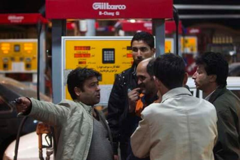 EDITORS' NOTE: Reuters and other foreign media are subject to Iranian restrictions on their ability to film or take pictures in Tehran. 



An Iranian man (L) speaks to a petrol station attendant (C) about the price of fuel at a petrol station in northwestern Tehran December 19, 2010. The price of gasoline will rise four-fold in Iran in the coming days, state television announced late on Saturday, as the most politically sensitive part of President Mahmoud Ahmadinejad's subsidy cuts plan takes effect.  REUTERS/Morteza Nikoubazl (IRAN - Tags: POLITICS ENERGY BUSINESS)
