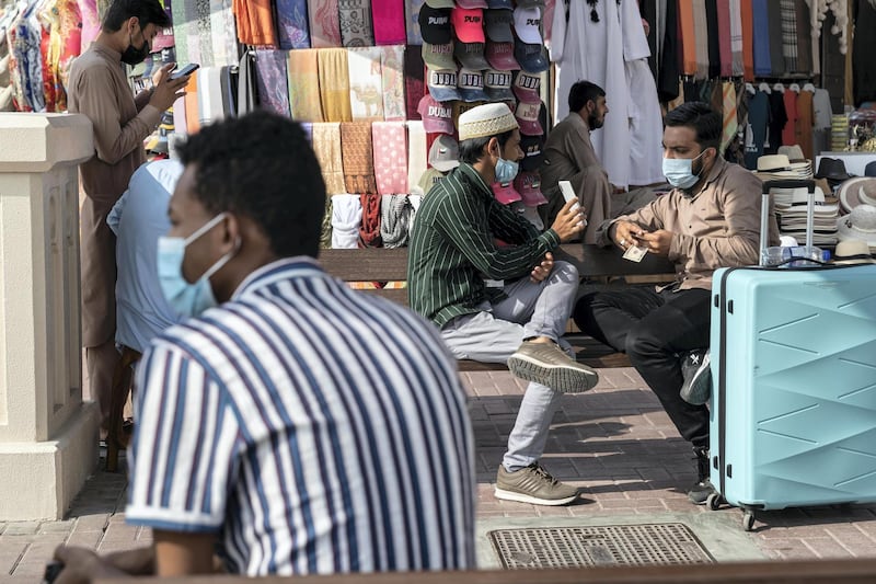 DUBAI, UNITED ARAB EMIRATES. 25 FEBRUARY 2021. COVID - 19 Standalone. Deira souk during the time of Covid. Men talk and wait while wearing face mask in the Abra station near the Spice souk. (Photo: Antonie Robertson/The National) Journalist: Nick Webster. Section: National.