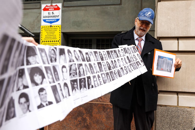 Paul Hudson, whose daughter Melina was one of the victims in the Pan Am Flight 103 bombing, holds up a banner with pictures of other victims outside the federal court. Getty / AFP