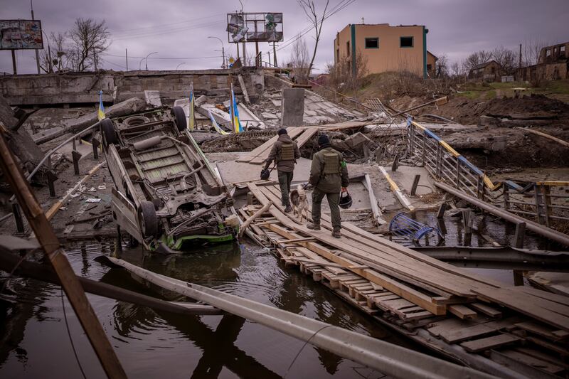 Ukrainian soldiers walk on a destroyed bridge in Irpin, on the outskirts of Kyiv. AP