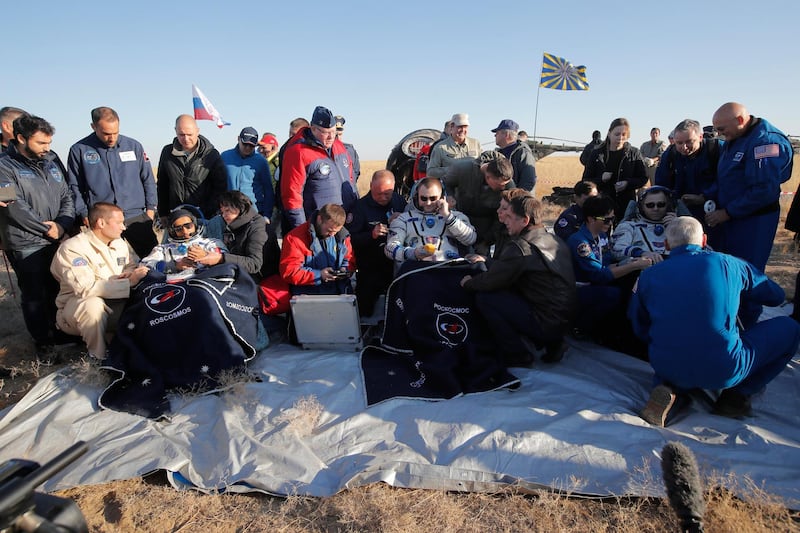 US astronaut Nick Hague, Russian cosmonaut Alexey Ovchinin, and UAE astronaut Hazzaa Ali Almansoori, sit in chairs shortly after landing. AP Photo