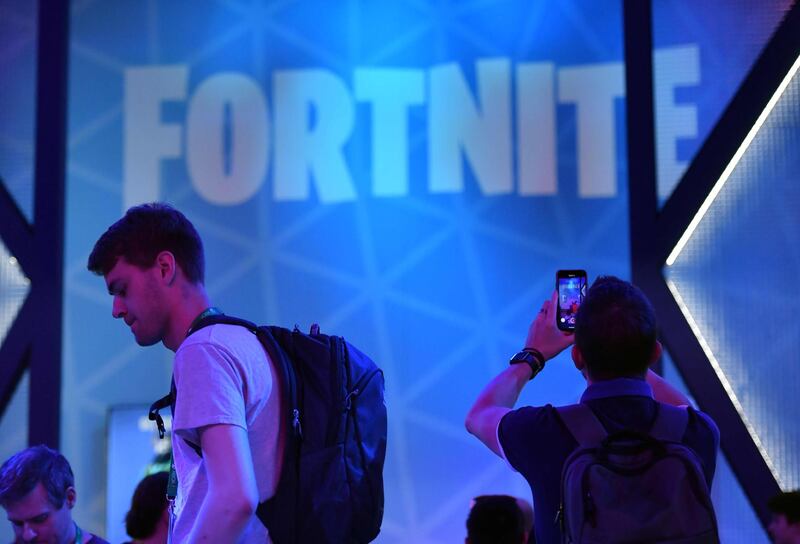 A visitor takes pictures at the stand of the "Fortnite" computer game at the media day of the Gamescom video games trade fair in Cologne, western Germany, on August 20, 2019. / AFP / Ina FASSBENDER
