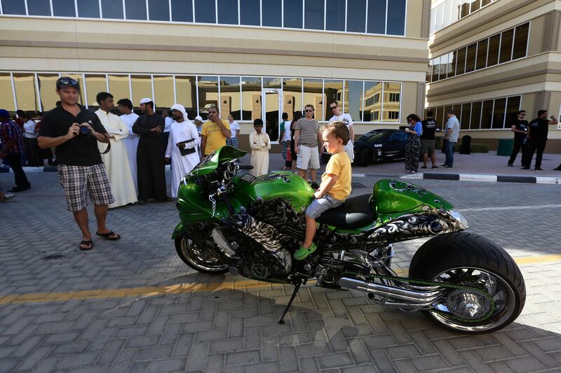 Dubai, May 31, 2013 - Russell Da Silva takes a photo of his son Dylan, 2, on top of a motorcycle at the Fast and Furious "Extreme Car Park" event at Studio City in Dubai, May 31, 2013. (Photo by: Sarah Dea/The National)

