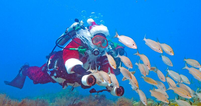 Spencer Slate, owner of a Keys dive shop, dons a Santa costume annually to offer underwater holiday photo opportunities and help promote awareness of an annual fundraiser for a local children's charity. Florida Keys News Bureau / AP