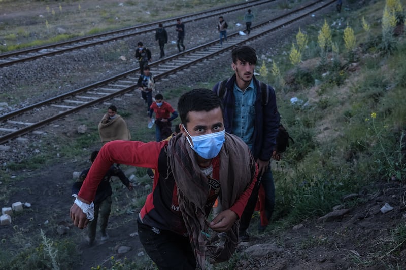 A group of Afghans run along railway tracks near Van city after crossing the Iran-Turkey border. EPA