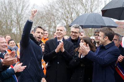 French President Emmanuel Macron and other officials celebrate the opening of the village. EPA