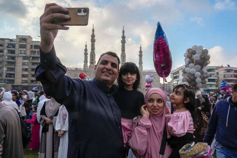 Muslim family members pose for a selfie as they celebrate Eid Al Fitr outside a mosque in Cairo. AP