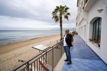 An hotelier looks at an empty beach from the terrace of his hotel in Sperlonga. This seaside town in Italy is just one of several holiday destinations hoping that the European Unions plans to resurrect Europe’s badly battered tourism industry will work. (AP Photo/Andrew Medichini, File)