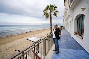 An hotelier looks at an empty beach from the terrace of his hotel in Sperlonga. This seaside town in Italy is just one of several holiday destinations hoping that the European Unions plans to resurrect Europe’s badly battered tourism industry will work. (AP Photo/Andrew Medichini, File)