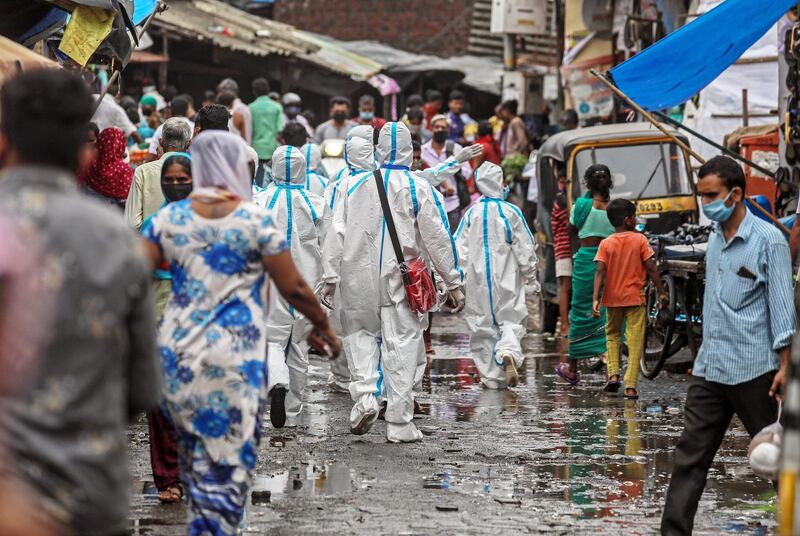 epa08530702 Indian health workers wearing personal protective equipment (PPE) walk in the crowded lanes as they leave after the medical checkup of the residents of a 'containment zones' in Ambujwadi area, a COVID-19 hotspot, in Mumbai, India, 06 July 2020. According to media reports, Indian become the third worst-affected country in the world in this coronavirus pandemic  EPA/DIVYAKANT SOLANKI  EPA-EFE/DIVYAKANT SOLANKI
