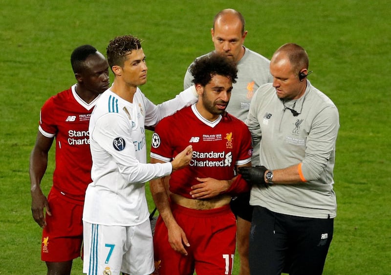 Soccer Football - Champions League Final - Real Madrid v Liverpool - NSC Olympic Stadium, Kiev, Ukraine - May 26, 2018   Liverpool's Mohamed Salah with Sadio Mane and Real Madrid's Cristiano Ronaldo as he is substituted after sustaining an injury   REUTERS/Phil Noble     TPX IMAGES OF THE DAY