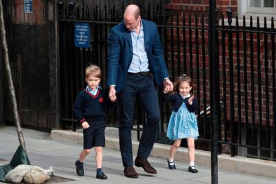 TOPSHOT - Princess Charlotte of Cambridge (R) waves at the media as she is led in with her brother Prince George of Cambridge (L) by their father Britain's Prince William, Duke of Cambridge, (C) at the Lindo Wing of St Mary's Hospital in central London, on April 23, 2018, to visit Catherine, Duchess of Cambridge, and their new-born brother, the Duke and Duchesses third child.  
Kate, the wife of Britain's Prince William, has given birth to a baby son, Kensington Palace announced Monday. "Her Royal Highness The Duchess of Cambridge was safely delivered of a son at 11:01 (1001 GMT)," the palace said in a statement. The baby boy weighs eight pounds and seven ounces (3.8 kilogrammes).
 / AFP PHOTO / Daniel LEAL-OLIVAS