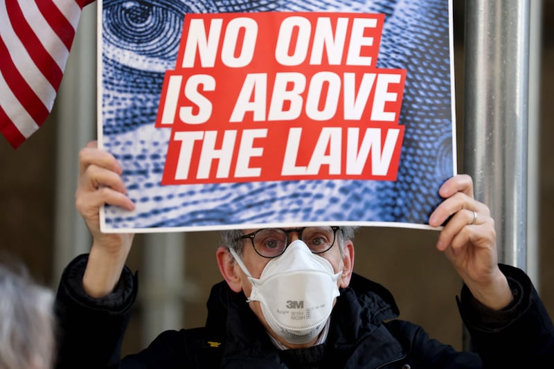 An anti-Trump demonstrator holds up a sign. Getty 