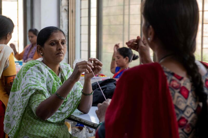 In this photo taken on February 14, 2020, women stretch a thread at the factory of fashion designer Anita Dongre on the outskirts of Mumbai. With stores in India and New York, multiple clothing brands and a global celebrity following, fashion designer Anita Dongre is a feminist powerhouse in a male-dominated industry. But her true ambition is to create an environmentally sustainable company, she says. - TO GO WITH Women-activism-India-fashion-economy-environment,INTERVIEW by Ammu Kannampilly
 / AFP / Laurène Becquart / TO GO WITH Women-activism-India-fashion-economy-environment,INTERVIEW by Ammu Kannampilly
