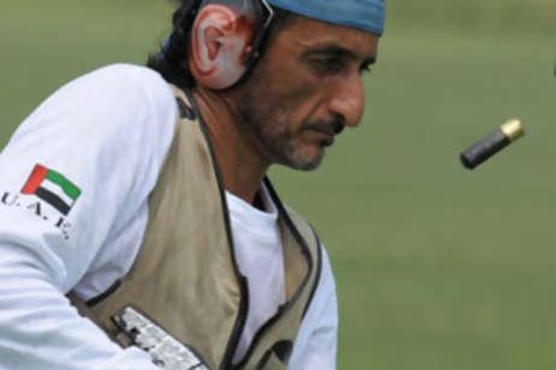 The Emirati shooter Sheikh Ahmed bin Hasher empties cartridges from his rifle during qualifying yesterday.