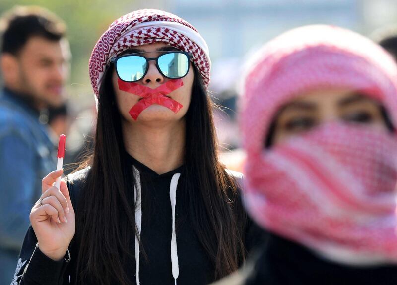 An Iraqi university student with mouth taped attends a protest in central Baghdad, Iraq.  EPA