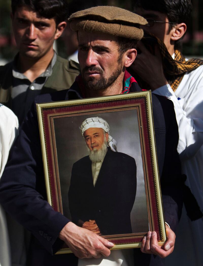 A supporter of Burhanuddin Rabbani, former Afghan president and head of the government's peace council, holds a picture of him while standing outside his house, a day after he was killed in Kabul September 21, 2011.
 A Taliban suicide bomber on Tuesday killed Rabbani, a dramatic show of insurgent reach and a heavy blow to hopes of reaching a political end to the war. REUTERS/Ahmad Masood (AFGHANISTAN - Tags: CIVIL UNREST POLITICS) *** Local Caption ***  KAB04_AFGHANISTAN-A_0921_11.JPG