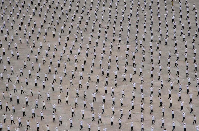 Performers in formation in a public square beneath the Arch of Triumph in Pyongyang. The gathering was understood to be a rehearsal for an expected upcoming Arirang Mass Games event in September. Ed Jones / AFP