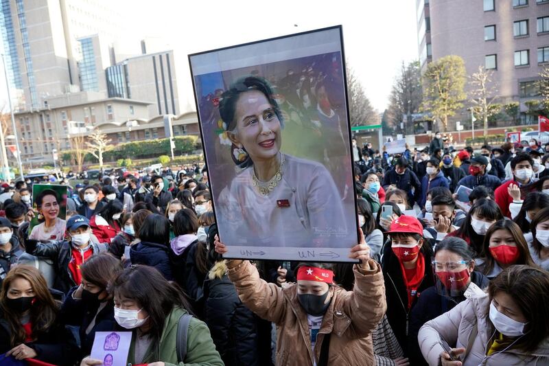 A Myanmar national in Japan holds up a portrait of Aung San Suu Kyi during a protest held in front of the United Nations University in Tokyo. EPA
