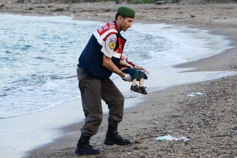 A Turkish gendarmerie retrieves the body of Syrian refugee Aylan Kurdi from a beach in Turkey. Nilufer Demir / Reuters