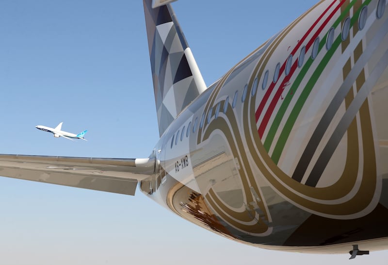 An Etihad Airbus A350-1041, in special livery to celebrate the UAE's Golden Jubilee, at the Dubai Airshow, with a Boeing 777X in the background. Chris Whiteoak / The National