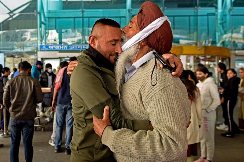 A passenger arriving from the UK receives a hug by his father after he went through a Covid-19 coronavirus test at Sri Guru Ram Dass Jee International Airport on the outskirts of Amritsar. AFP