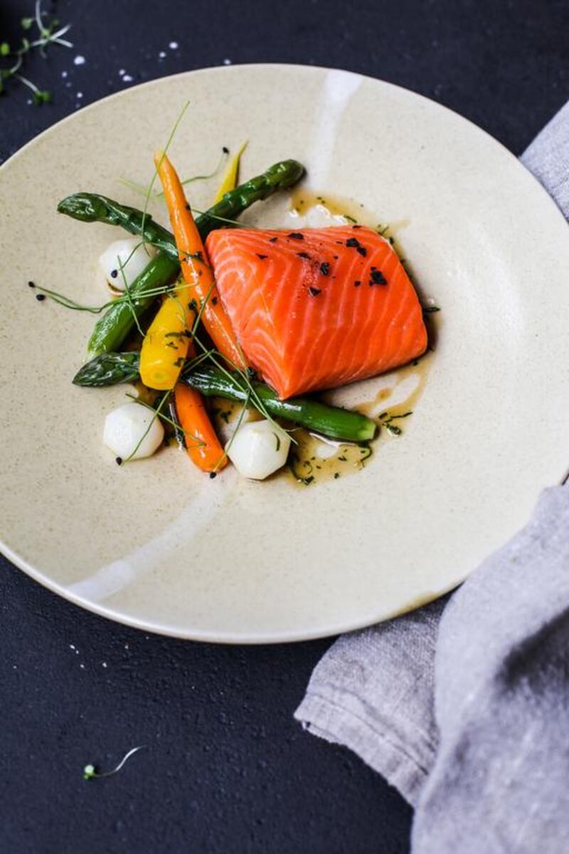 The signature dish of olive oil confit salmon with heirloom vegetables and a herb jus. Courtesy The Atlantic Dubai