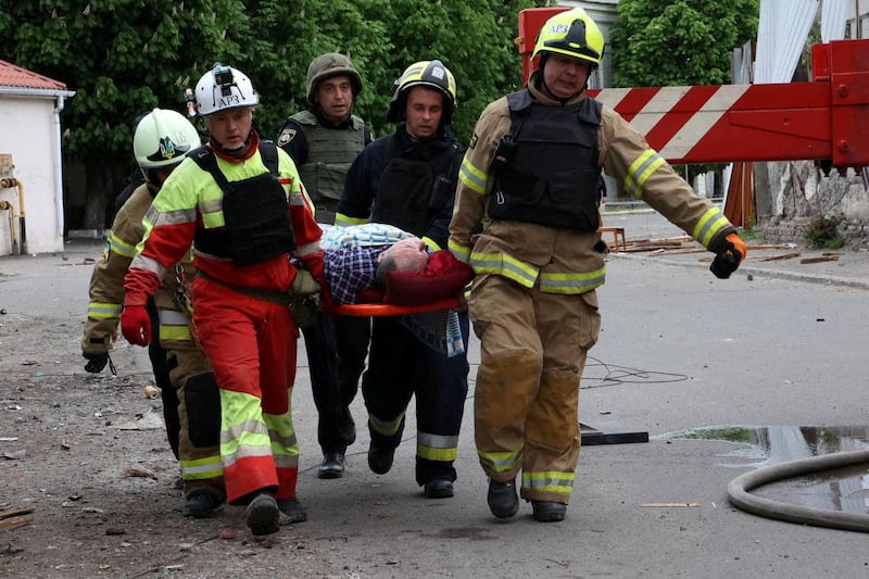 Rescues carry a person wounded by a Russian missile strike in Dnipro. Reuters