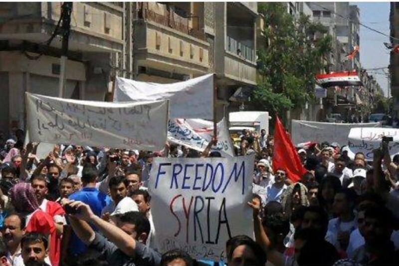 Syrian protesters holding banners as they march during a demonstration in Homs.