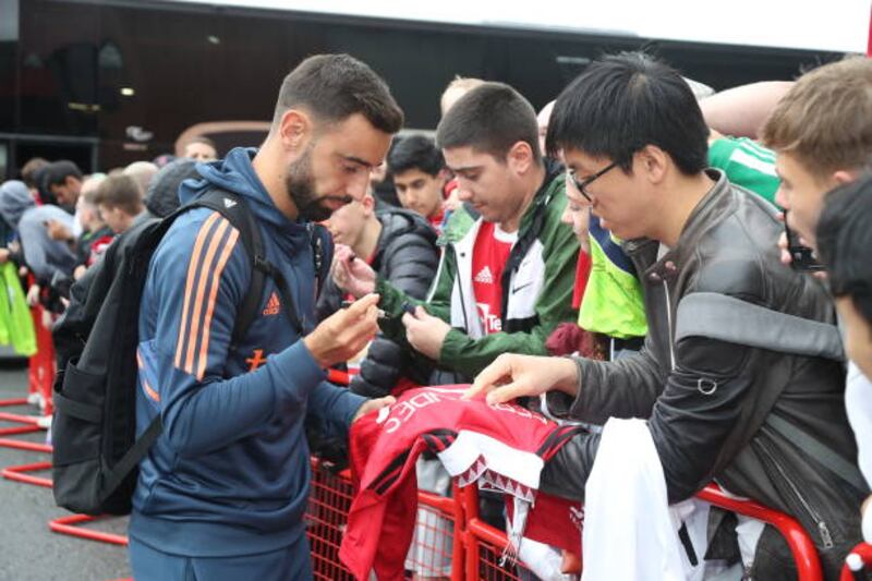 Bruno Fernandes signs for fans at Old Trafford. Getty