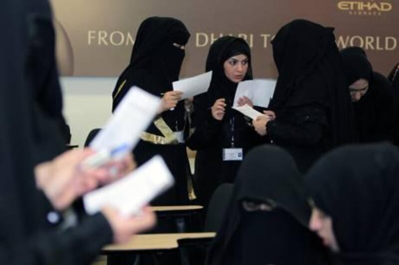 ABU DHABI, UNITED ARAB EMIRATES - OCTOBER 10:  Emirati women from Al Ain gather for an orientation session at the Etihad Airways Training Centre in Abu Dhabi on October 10, 2010. Approximately 80 women will be training to work in an Etihad contact centre in Al Ain and will begin work at the centre in January 2011. Pictured is Hind Abdulla Rashed al Nuami (C), while she interacts with other trainees.  (Randi Sokoloff / The National)  For News story by Haneen