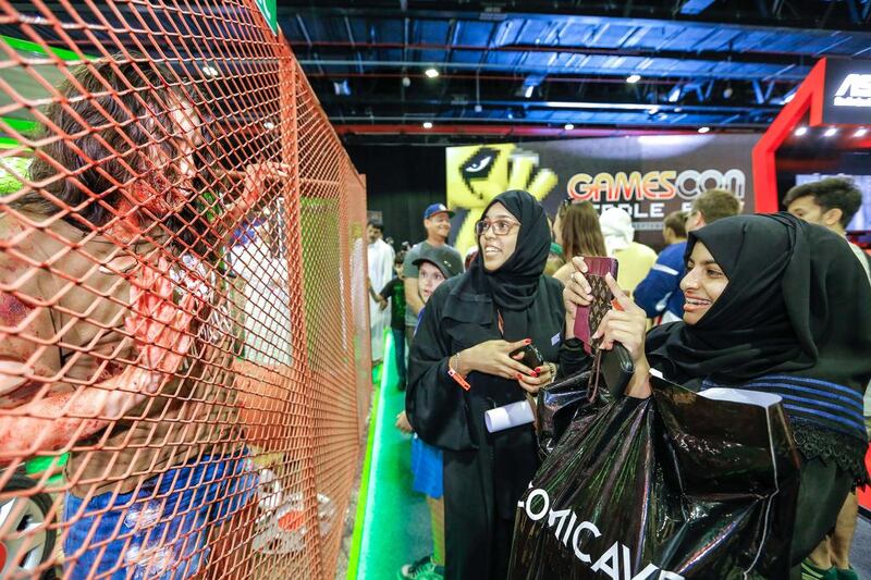 Visitors to the Middle East Film & Comic Con take photos of Kirsten Beers, dressed as the girl zombie from the video game State of Decay Year One. Victor Besa for The National.