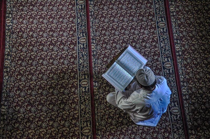 SRINAGAR, J&K, INDIA - 2018/05/31: A Kashmiri man recites the Quran during the ongoing holy month of Ramadan in Srinagar, Indian administered Kashmir. Muslims throughout the world are marking the month of Ramadan, the holiest month in the Islamic calendar during which devotees fast from dawn till dusk. (Photo by Saqib Majeed/SOPA Images/LightRocket via Getty Images)