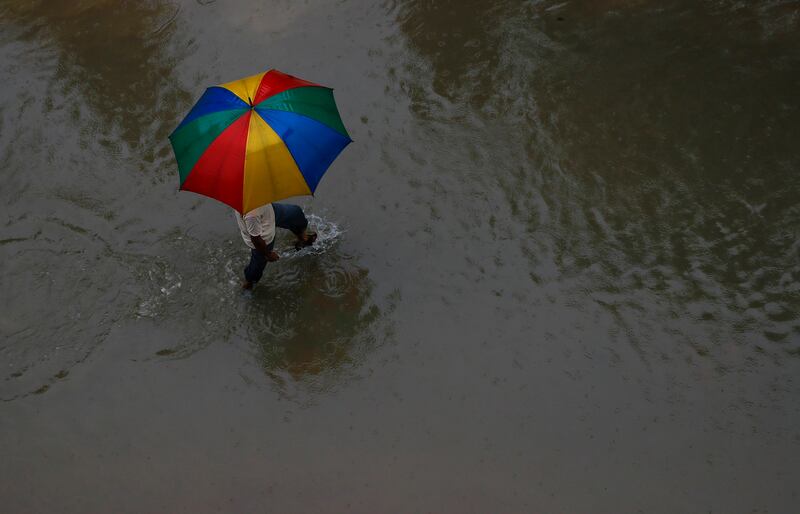 A man with an umbrella walks at a flooded area in Rajbiraj, Saptari district, Nepal. Narendra Shrestha / EPA