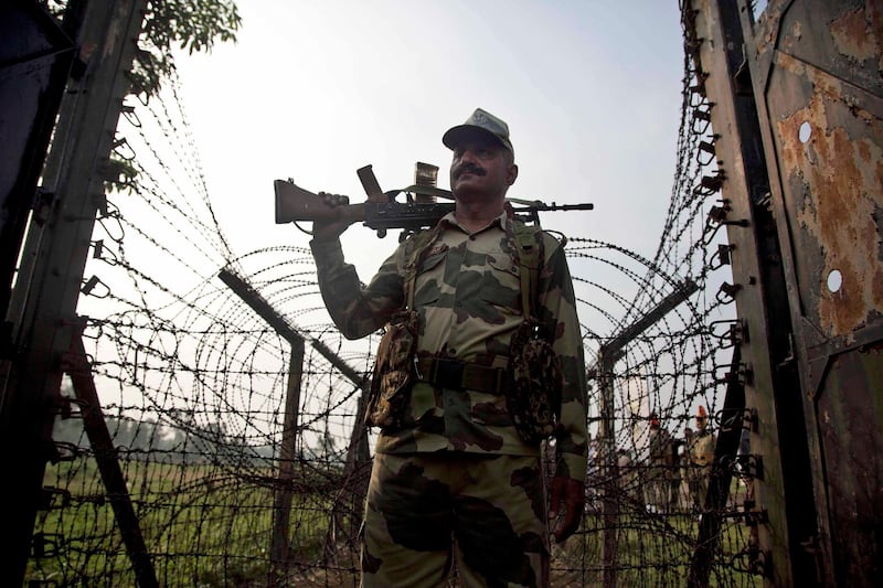 An Indian Border Security Force soldier stands guard near a fence on the India- Bangladesh border at Thakuranbari village, in the northeastern Indian state of Assam, Friday, Sept. 2, 2016. Chief Minister of Assam state Sarbananda Sonowal has sought help from the central government in sealing the porous border, one of the core issues of the ruling Bharatiya Janata Party's election campaign in Assam. (AP Photo/ Anupam Nath)