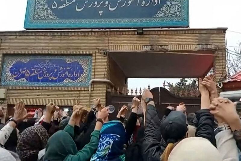 Families chant slogans outside an education ministry building in Tehran. AFP