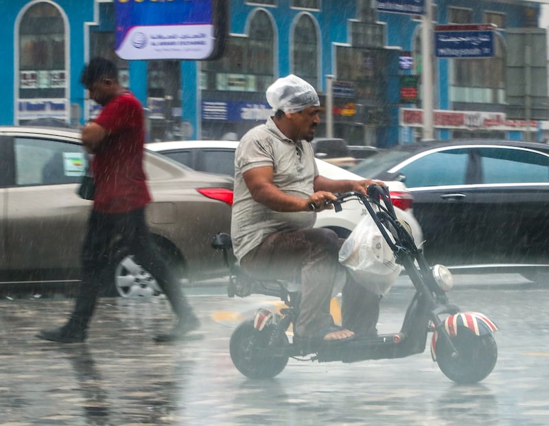Riding an electric scooter amid the downpours in Abu Dhabi. Victor Besa / The National