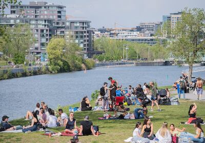 People gather next to the Lachine Canal on a warm spring day in Montreal, Saturday, May 15, 2021, as the COVID-19 pandemic continues in Canada and around the world.  (Graham Hughes/The Canadian Press via AP)