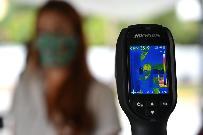 A woman undergoes temperature check as a precaution against the spread of Covid-19, at the entrance of the zoo in Cali, Colombia. AFP