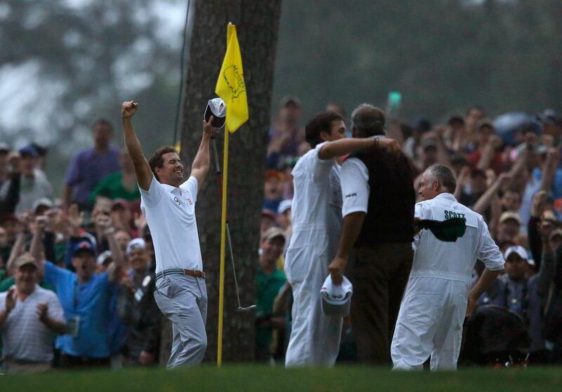 Angel Cabrera of Argentina (R) hugs his son, caddie Angel Cabrera Jr. as Adam Scott of Australia (L) celebrates winning the Masters during a playoff in the 2013 Masters golf tournament at the Augusta National Golf Club in Augusta, Georgia, April 14, 2013. REUTERS/Phil Noble (UNITED STATES  - Tags: SPORT GOLF)   *** Local Caption ***  AUG123_GOLF-MASTERS_0415_11.JPG