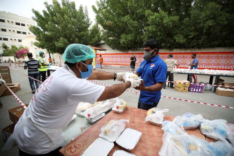 Volunteers wearing protective face masks and gloves hand out Iftar meals provided by the authorities, following the outbreak of the coronavirus disease (COVID-19), during the holy month of Ramadan, in Manama, Bahrain, May 6, 2020. REUTERS/Hamad I Mohammed