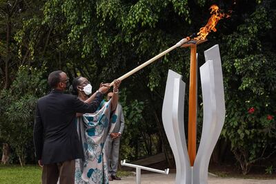 Rwanda's President Paul Kagame (L) and First Lady Jeannette Kagame (R) light a remembrance flame for the 27th Commemoration of the 1994 Genocide against the Tutsi at the Kigali Genocide Memorial in Kigali, Rwanda, on April 7, 2021. / AFP / Simon Wohlfahrt
