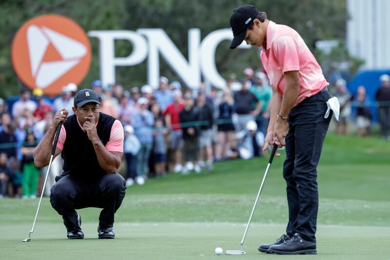 Tiger Woods watches son Charlie Woods putt on the 18th green during the first round of the PNC Championship. AP