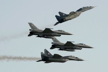 FILE - Two Polish Air Force Russian made Mig 29's fly above and below two Polish Air Force U. S.  made F-16's fighter jets during the Air Show in Radom, Poland, on Aug.  27, 2011.  In a private video call with American lawmakers over the weekend, Ukrainian President Volodymyr Zelenskyy made a “desperate” plea to the United States to help Kyiv get more warplanes to fight Russia's invasion and retain control of its airspace.  (AP Photo / Alik Keplicz, File)