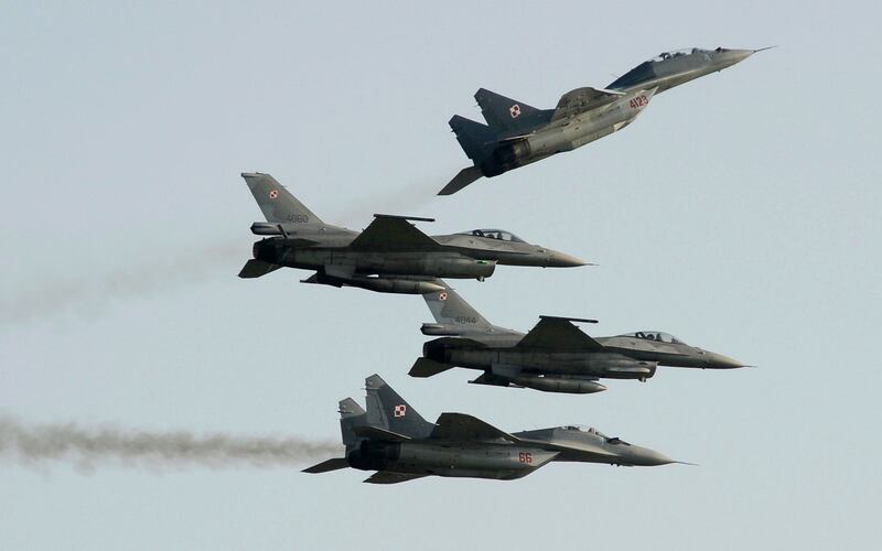 Two Polish Air Force Russian-made Mig 29s fly above and below two Polish Air Force US-made F-16s  during an air show in Radom, Poland. AP