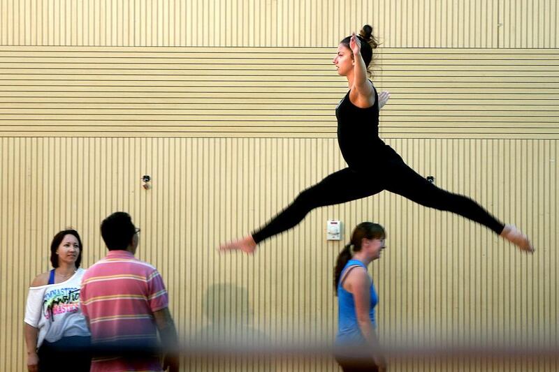 Emily Golding-Ellis leaps during a floor-mat routine at a gymnastics session for grown-ups. In Abu Dhabi, Little Stars Gymnastics Club and Jump Sports Academies offer classes. Delores Johnson / The National

