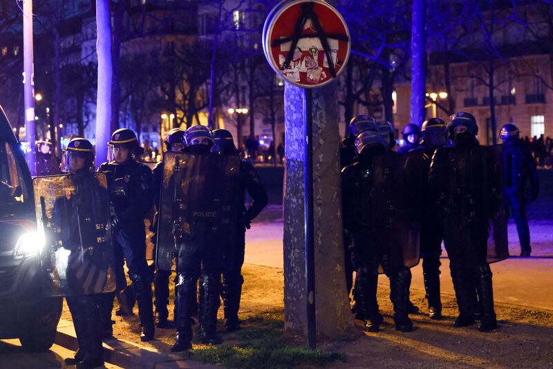French riot officers stand guard at a Paris protest on Monday night. Reuters