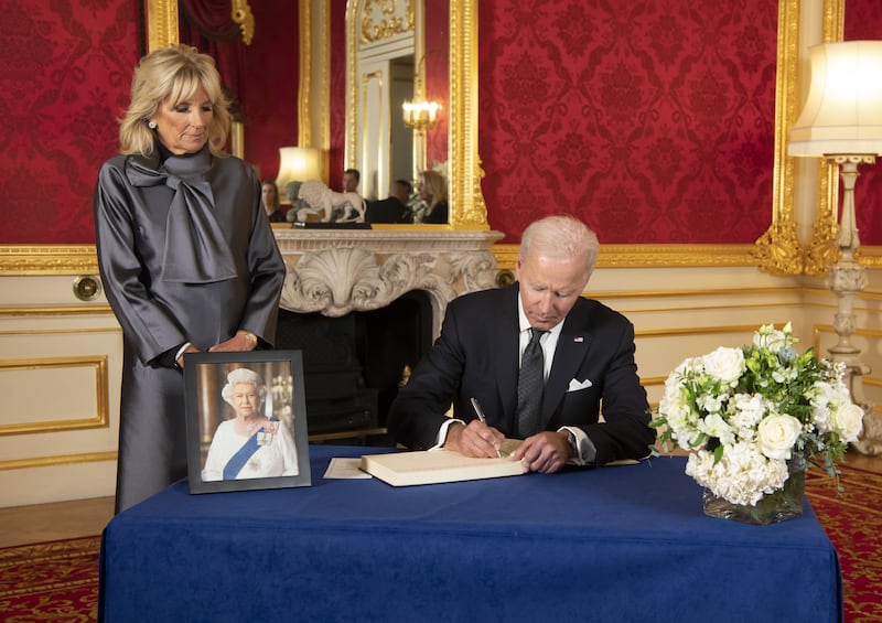 US President Joe Biden accompanied by the First Lady Jill Biden signs a book of condolence at Lancaster House in London. PA